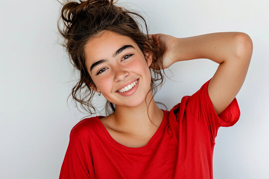 Elegant woman with hair, happy and smiling while touching her hair against a grey background. posing for a beauty concept