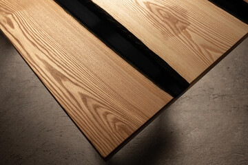 Expensive vintage furniture. The table is covered with epoxy resin and varnished. Luxury quality wood processing. Wooden table on a dark background. Black river made of epoxy resin.