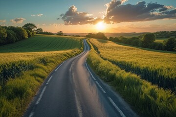 Fototapeta premium Winding Country Road Through Green Fields At Sunset