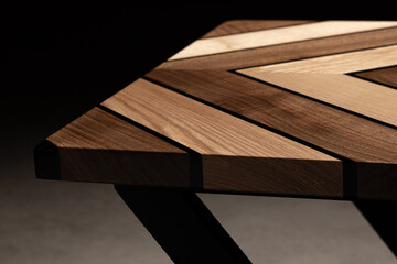 Expensive vintage furniture. The table is covered with epoxy resin and varnished. Luxury quality wood processing. Wooden table on a dark background. Swirling geometric patterns in the form of a maze.