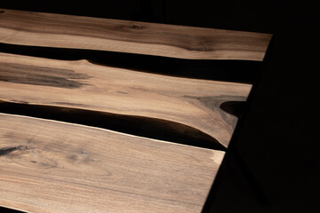 Expensive vintage furniture. The table is covered with epoxy resin and varnished. Luxury quality wood processing. Wooden table on a dark background. Black river made of epoxy resin.