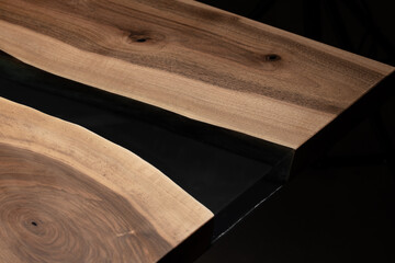 Expensive vintage furniture. The table is covered with epoxy resin and varnished. Luxury quality wood processing. Wooden table on a dark background. Black river made of epoxy resin.