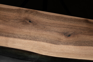Expensive vintage furniture. The table is covered with epoxy resin and varnished. Luxury quality wood processing. Wooden table on a dark background. Black river made of epoxy resin.