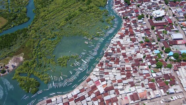 Discover Lombok from above: a lively fishing port, a dense mangrove forest, and a bustling village all intertwine, showcasing a unique blend of tradition and vibrant community life, Indonesia