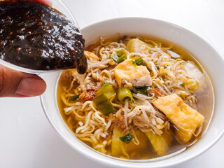 Lontong balap,is Indonesia traditional dish, from Surabaya, East Java. It consists of bean sprouts, tofu, lontong, and sprinke with crispy fried garlic and also petis. In isolated white.
