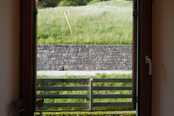 View from bedroom window frame of natural landscape of green hill range