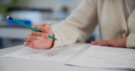 Education, exam and hands at desk with paper, test and multiple choice assessment at school. Student, person or writing on document for answer, quiz or questionnaire in class for learning evaluation