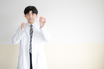 歯ブラシと白衣の男性