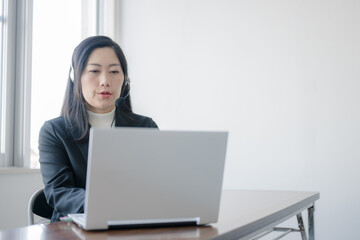 インカムとPCとスーツ女性