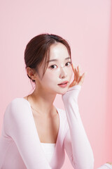 ピンク背景で撮影をした若い女性のキャッチーなビューティー...