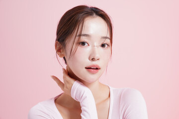 ピンク背景で撮影をした若い女性のキャッチーなビューティー...