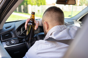 Man drinking alcohol while driving a car. Don't drink and drive concept