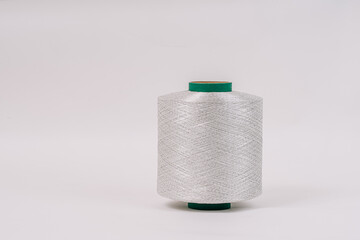 A spool of fiberglass threads with a green core, placed against a plain white background, showcasing the detailed, tightly wound fibers.