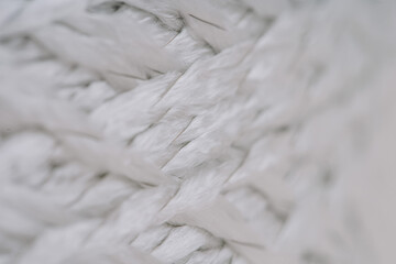 Close-up of intertwined fiberglass strands with visible metal threads, showing the texture and structure of the material.