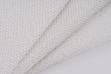 Close-up of three different fiberglass woven fabrics with visible metal threads, showcasing various textures and weave patterns in a side-by-side layout.