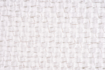 Close-up of white woven fabric with visible metal threads, highlighting the intricate texture and pattern in a macro view.