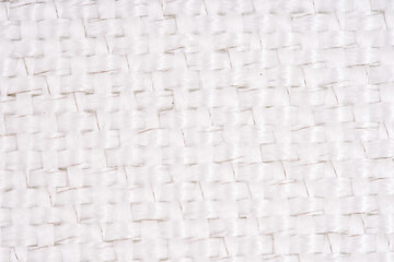 Close-up of white woven fabric with visible metal threads, highlighting the intricate texture and pattern in a macro view.