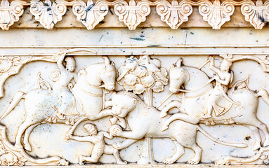 An ancient bas-relief of hindu deity made of stone carved on the wall of a palace in Jaipur, India	