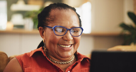 Happy, relax and mature black woman on laptop in living room for watching movies, video and tv show. Retirement, home and person on computer for online media, entertainment and internet on sofa