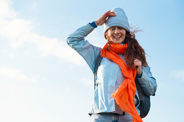 Young Woman in Blue Attire and Orange Scarf Enjoying Breeze Outdoors on  Sunny Day