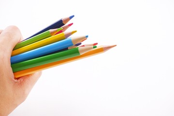 Colorful wooden colored pencils on woman hand isolated on white backdrop with copy space image.