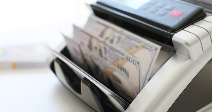 Banknote counter machine counts dollar bills in bank office. Specialized device for accurate financial operations with cash without errors
