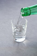 韓国の伝統的な蒸留酒、よく冷えた韓国焼酎（ソジュ）をグラスに注ぐ