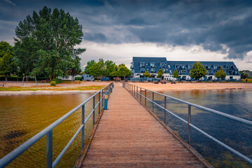 Gloomy summer cityscape of Dranske villige with old wooden pier, Germany, Europe. Dramatic morning...