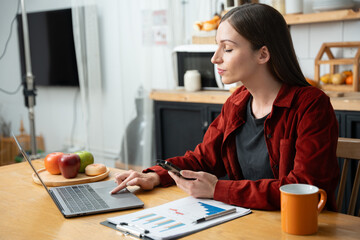 Woman uses laptop to work in the kitchen