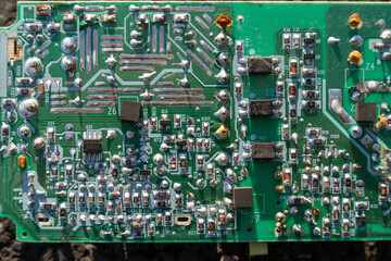 Obraz premium broken electronics board on ground outdoors in sunlight
