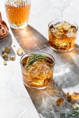 a glass of whiskey with rosemary