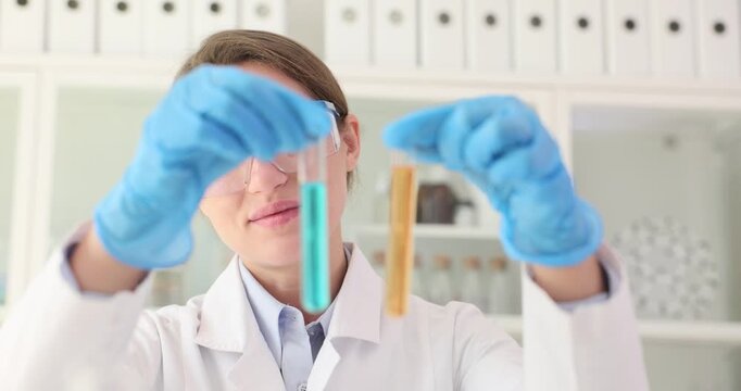 Female scientist scrutinizes multiple test tubes with colorful liquids. Researcher seeks to uncover notable distinctions and commonalities