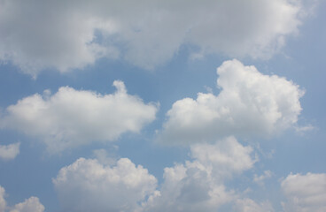 It's a blue sky with atmospheric puffy clouds.