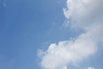 It's a blue sky with atmospheric puffy clouds.