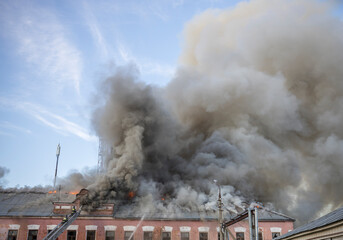 A building is on fire and smoke is billowing out of it