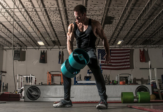 Ripped man lifts weights at gym