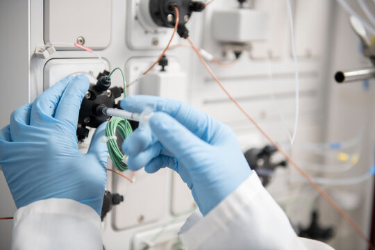 Scientist making adjustments to a machine in a biotech lab