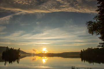 Obraz premium Sunset over a magnificent fishing lake in the Canadian forest