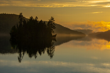 Obraz premium Sunset over a magnificent fishing lake in the Canadian forest