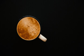cup of coffee with foam on black background