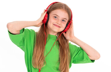 Happy girl in green summer outfit dancing enjoying music in red headphones on white background