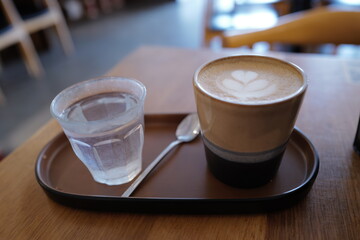 Cup of cappuccino and water on a table