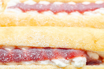 A jelly donut with a jelly filling and a powdered sugar topping