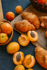Fresh apricots and croissants on a burlap cloth