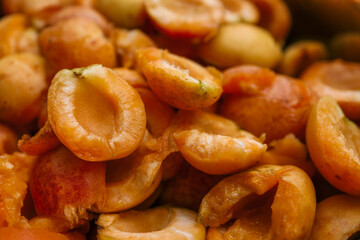 Close-up of halved apricots showcasing their vibrant orange color and juicy texture. The fresh...