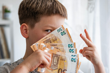 child holding euros, euro banknotes money in fan, euro money, rejoices in success, anticipates what...