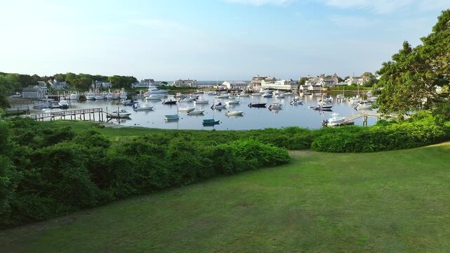 Wychmere harbor in harwich, cape cod with boats and lush green garden, aerial view