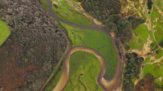 looking down on river Pysgodlyn winding through the lush green landscape at Three cliffs bay