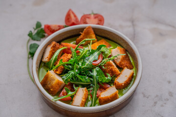 chicken with vegetables in green sauce on a light background