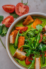 chicken with vegetables in green sauce on a light background